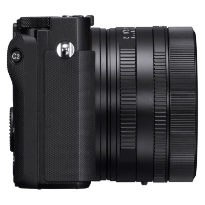 Sony DSC RX1R III van de zijkant gezien, met een strak ontwerp en een zwart objectief. De grip is stevig en textuur is zichtbaar.