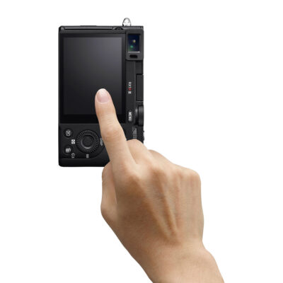 Sony DSC RX1R III toont een hand die het touchscreen van de camera aanraakt, terwijl de achterkant van de camera zichtbaar is.