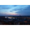 Sony DSC RX1R III toont een panoramisch uitzicht over de stad bij schemering, met lichten en reflecties in het water.